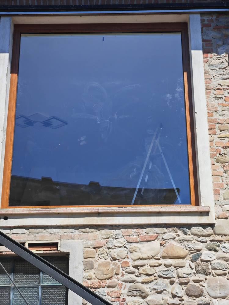 Vetrata fissa in alluminio effetto legno su edificio in pietra